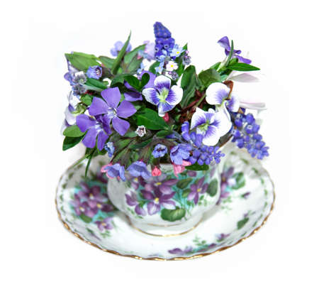 A china cup filled with appropriate spring flowers. の写真素材