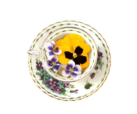 A china teacup floating pansies and violets. の写真素材
