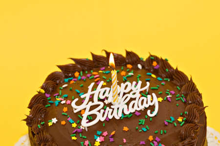 A chocolate birthday cake with candle and words.の写真素材