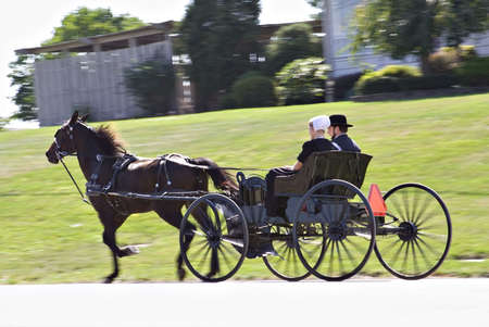 A young Amish couple in Ohio - riding in their horse-drawn  buggy.  の写真素材