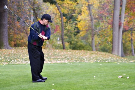 A male golfer playing game on a beautiful fall day の写真素材