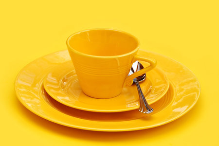 A place setting of vintage retro dinnerware - yellow on yellow.