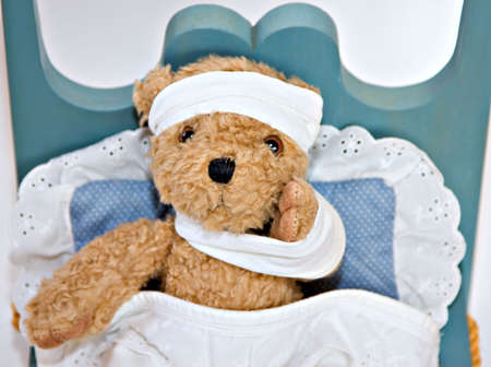Bear wrapped in bandages in a sick bed. の写真素材