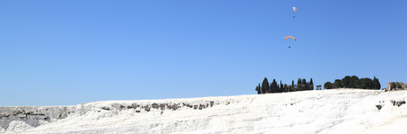Pamukkale: Paraglider flying over the caclium deposits from the natural thermal springs.の写真素材