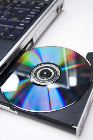 Close up image of a cd/dvd being inserted into a laptop drive, focus around the disk itselfの写真素材