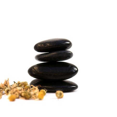 Zen stones & camomile flowers isolated on white - shallow depth of fieldの写真素材
