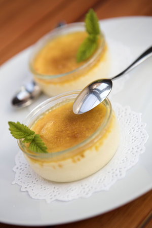 Creme brulee desserts garnished with a mint sprig - shallow dof