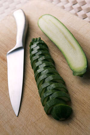 Courgette on a chopping board, half is sliced - shallow dof の写真素材