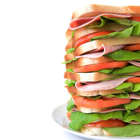 Tall sandwich of ham, tomato & lettuce on white bread - isolated on whiteの写真素材
