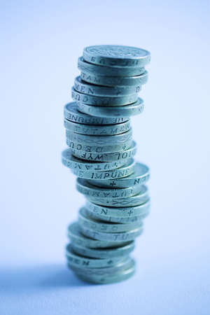 Stack of GBP pound coins - shallow dof with deliberate blue castの写真素材