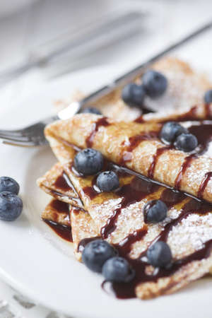 Freshly prepared crepes with blueberries & chocolate sauce - shallow dofの写真素材