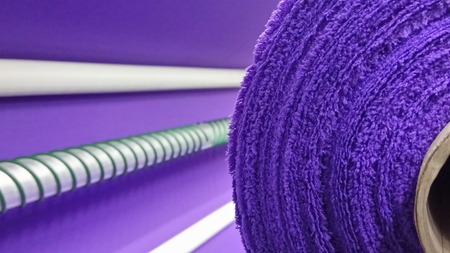 New industrial violet roll, violet background. Concept: material, fabric, manufacture, garment factory, new samples of fabrics.の写真素材