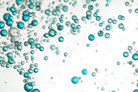 Many small blue air bubbles rising in clear waterの写真素材