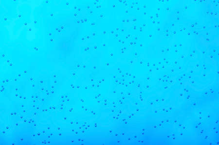 Many small air bubbles in dark blue waterの写真素材