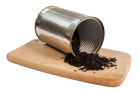 Black tea in a silver tin can, on a small cutting boardの写真素材