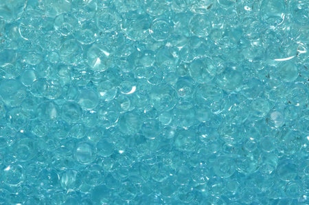 Many blue liquid bubbles flouding in a clear glassの写真素材