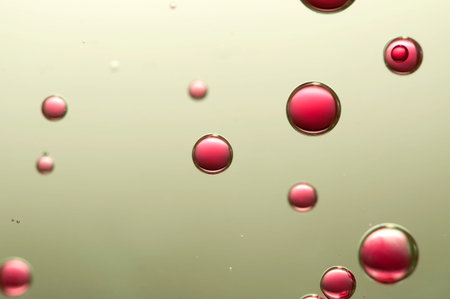 Red wine bubbles soars in a golden glass of wineの写真素材