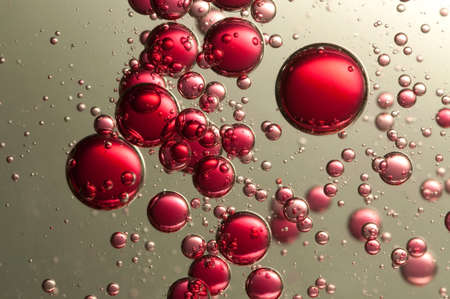 Many red fizz bubbles float over a dark backgroundの写真素材