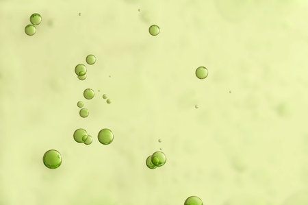 Green liquid bubbles soars over a blurred backgroundの写真素材