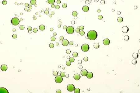 Green juice bubbles flows over a light blurred background