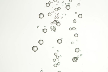 Beautiful round air bubbles flows over a light background