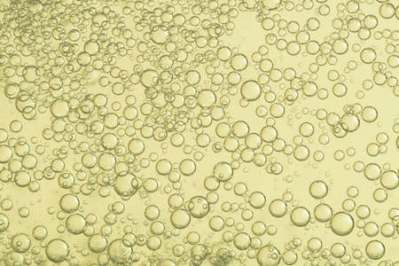 Many small golden bubbles flows in a glass.の写真素材