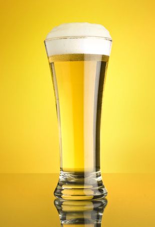 glass of beer on yellow backgroundの写真素材