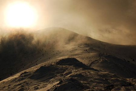 Top of the high winter mountain and sun in the mist
