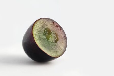 Half of black grape on white backgroundの写真素材