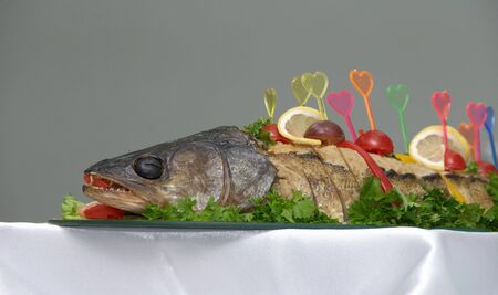 Stuffed pike fish with vegetables and fruitsの写真素材