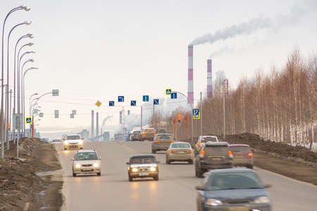 Kemerovo, Russia - march 2019, cars move along carriageway of bypass road, smoking chimneys, long exposure, movementのeditorial素材
