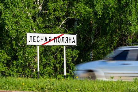 road sign end of town Lesnaya Polyana or Forest Glade, a satellite city of Kemerovo, green forest, grass and gray avtoの写真素材