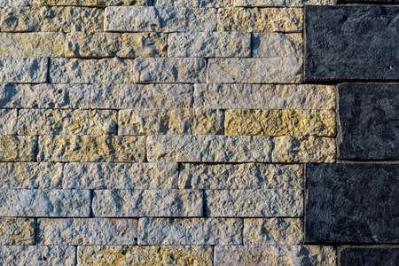 the joint of stone walls of two different types of stone - dark and light, large and medium sizeの写真素材