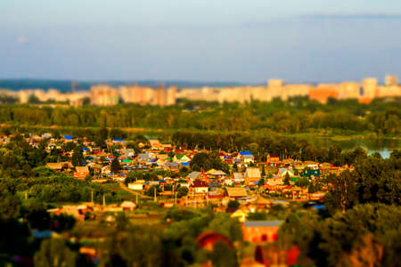 at sunset, an area with individual houses, far beyond the river, a block of multi-storey residential buildings, tilt shiftの写真素材