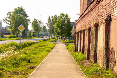 street of a small settlement with individual buildings and a brick structure along the sidewalk, selective focusの写真素材