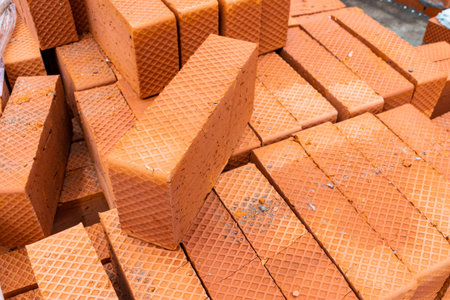 burnt bricks of orange color with corrugated sides lie on a pallet, selective focus