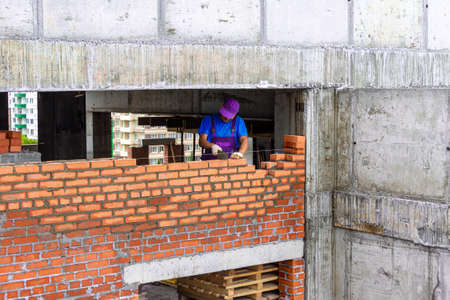 Bricklayer lays a partition during the construction of a frame monolithic structure, selective focusの写真素材