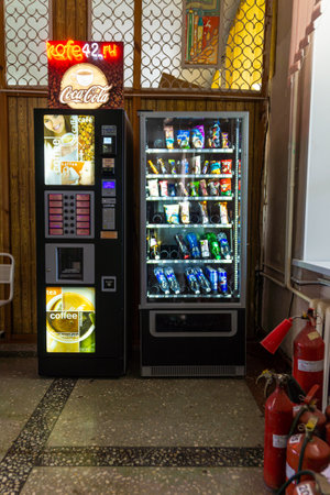 Russia, Kemerovo - 07, 2021. Coffee vending machine, near the vending machine for drinks and sweets are in a room with fire extinguishers, selective focusのeditorial素材