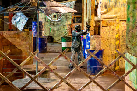 indoor paintball - player shoots from cover, selective focusの写真素材
