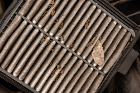 Seasonal maintenance of the car's engine includes replacing the air filter, which is clogged with dust and debris flying in the air, selective focusの写真素材