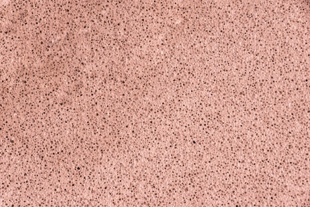 Digitally color-graded aerated concrete texture showing micro voids and rough matte finish....