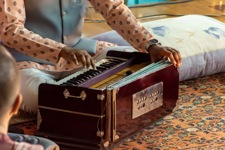Close-up of musicians hands operating keys and bellows of traditional Indian instrument harmonium. Selective focusの写真素材