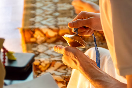 Cultural practice results in playing cymbals to anchor attention and maintain calm. Warm lighting emerges from decorative source enhancing inner stillness. selective focusの写真素材