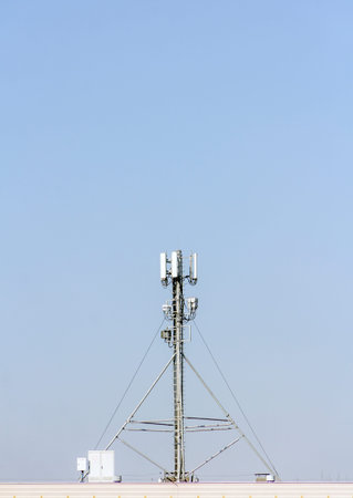 5g mobile telephone relay standing on the roof of a residential buildingの写真素材