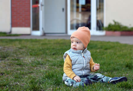 A portrait of a one-year-old baby boy sitting on the lawn in Gdynia, Polandの写真素材