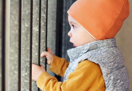 One-year-old baby holding onto the gate in Gdynia, Polandの写真素材