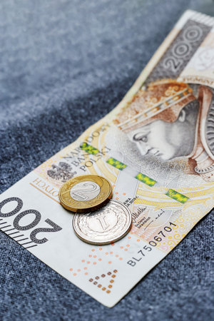 Two Polish coins and a banknote on a gray, material backgroundの写真素材