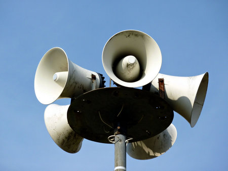 Lots of white loudspeakers on a column