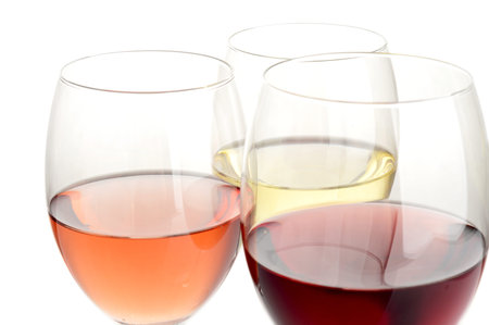 Rose, white and red wine in glasses on white background