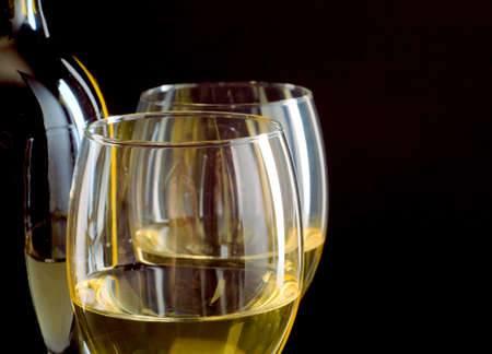 Close up image of two glasses of white wine on black backgroundの写真素材
